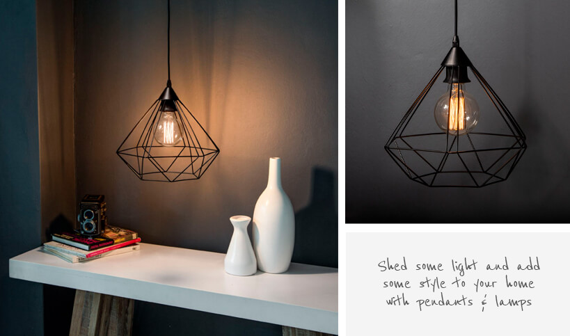 Geometric black metal light pendant against grey wall in setting with white console table and decorative items